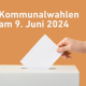 Person wirft Wahlschein in Wahlurne mit Titel „Kommunalwahlen 2024“